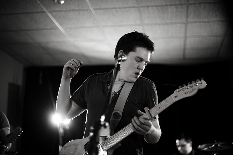 Eoghan Colgan Playing Electric Guitar Eoghan Colgan playing an electric guitar with a band in black and white