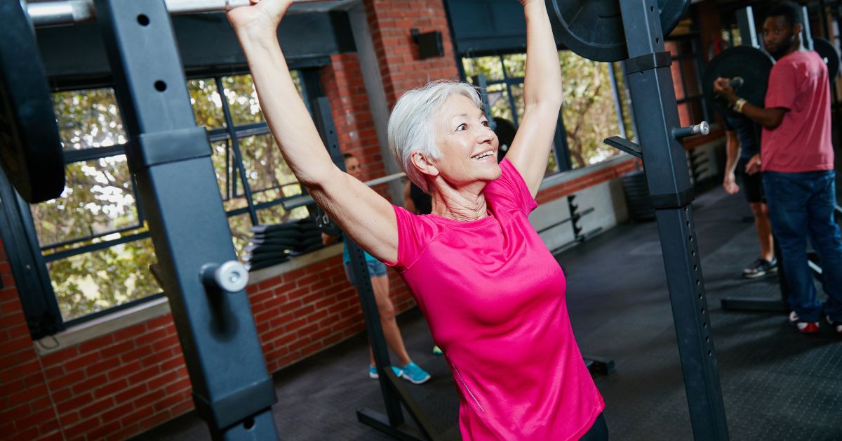 An older woman strength training in a gym — aging muscle retains its full capacity to respond to exercise