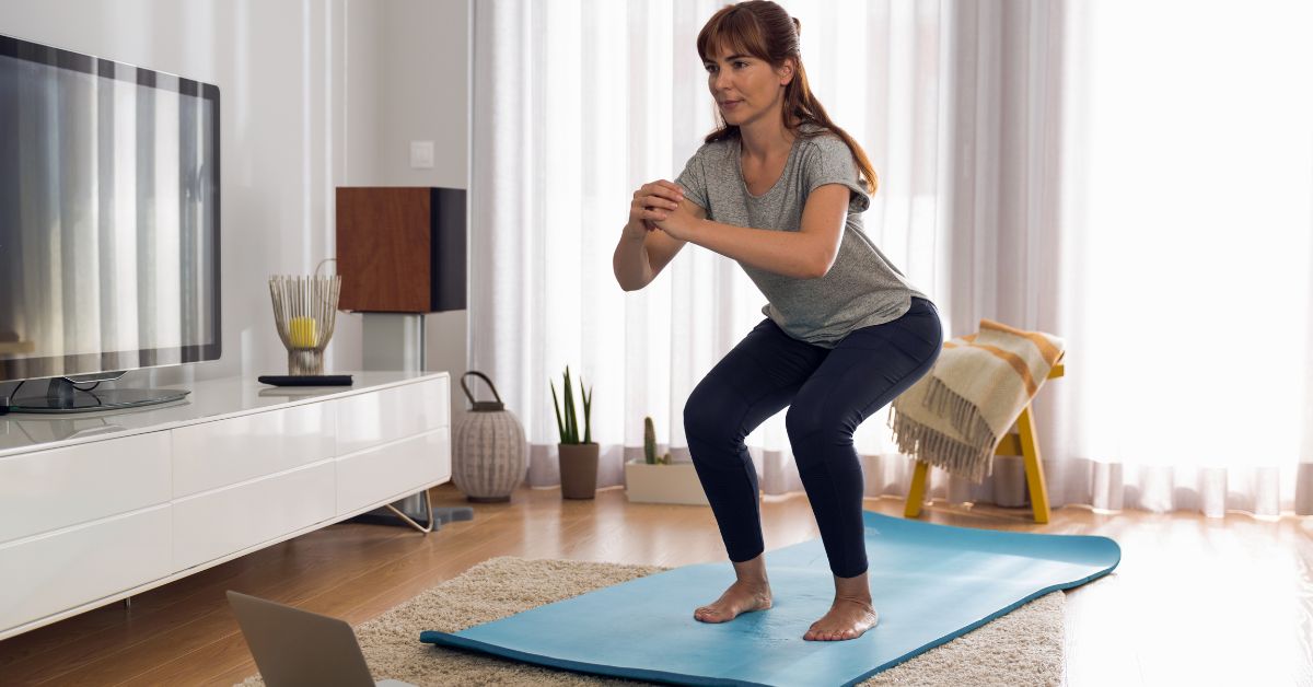 longevity-tips-strength-training-stressfreelongevity Woman doing bodyweight squats at home — strength training for longevity