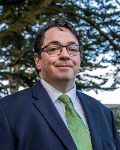 Professor John Cryan - headshot wearing suit and green tie