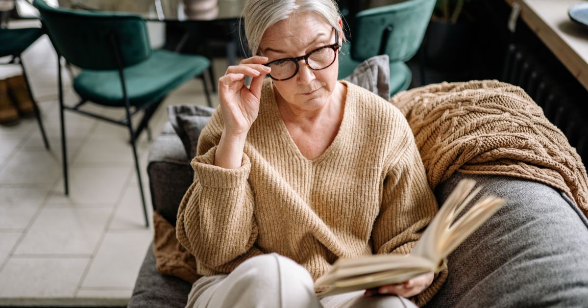 Older woman reading a book at home, relaxed and engaged