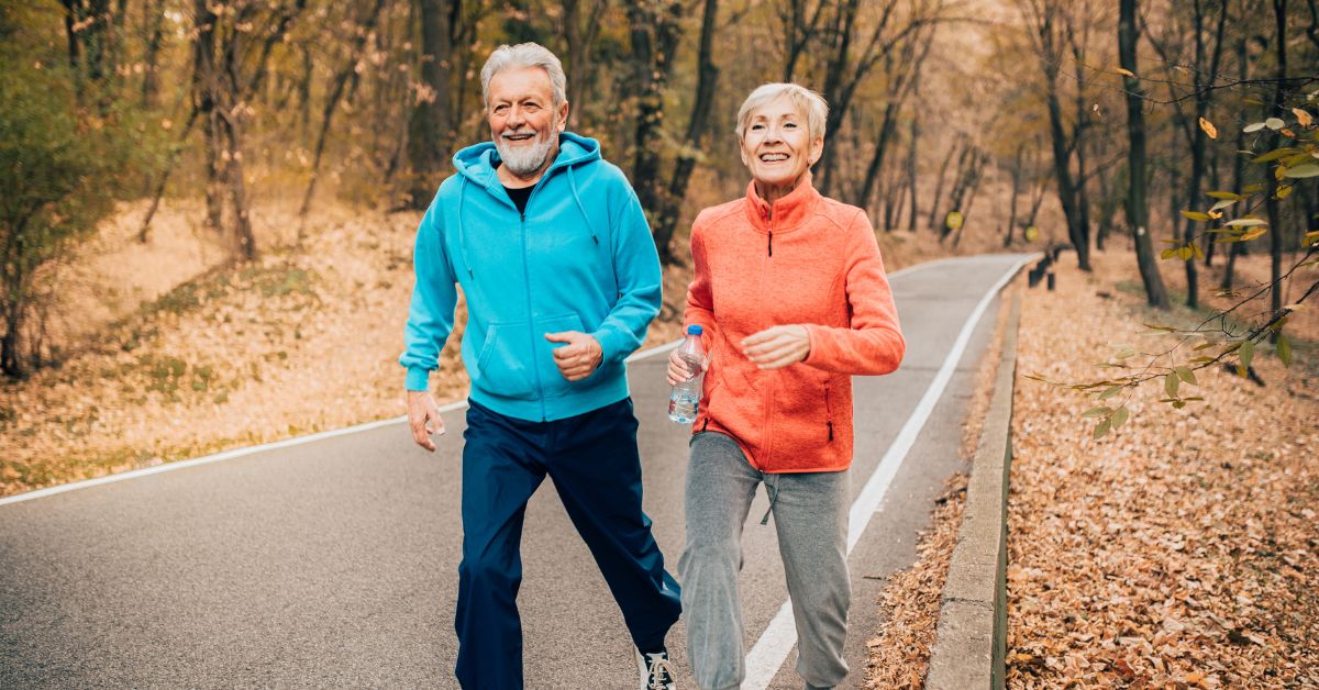 vo2-max-improve-exercise-couple-jogging-stressfreelongevity Older couple jogging together on autumn trail — consistent aerobic exercise improves VO2 max at any age