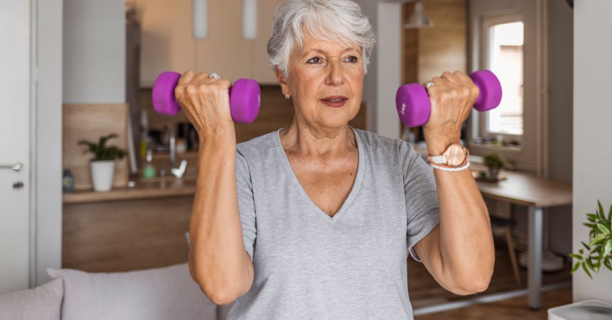 Older woman performing a strength training exercise with light dumbbells at home