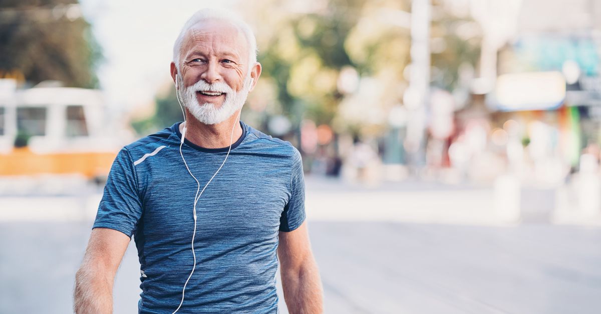 losing-weight-increase-testosterone-stressfreelongevity. Healthy older man walking outdoors and smiling — losing weight can increase testosterone