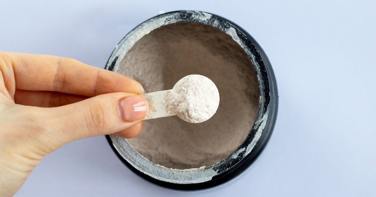 creatine-side-effects-scoop-stressfreelongevity A single scoop of creatine monohydrate held over the tub