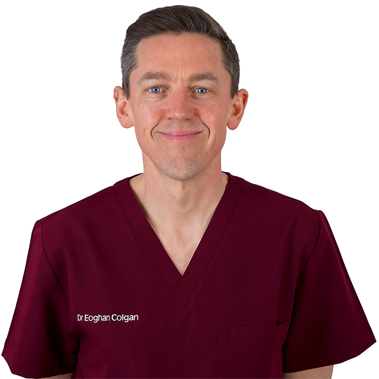 Dr Eoghan Colgan, medical doctor, smiling, in burgundy scrubs